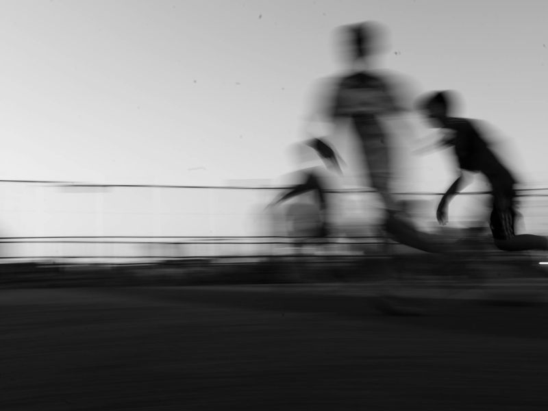 Athlete running on a track, captured in a motion blur to convey speed.